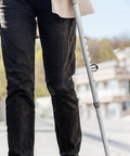 Person using crutch with Eight Pieces C Shaped Locking Clips for walking aid accessories on 22mm round pipe outdoors.