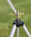 Metal Pulsating Sprinkler With Quick Connect Set And XT Tripod 48 Inch High Reach spraying water on grass