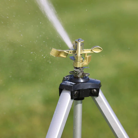Metal Pulsating Sprinkler With Quick Connect Set And XT Tripod 48 Inch High Reach spraying water on grass