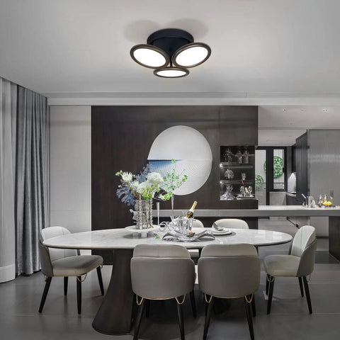 Modern dining room with elegant decor and sleek black circular ceiling light fixture with three illuminated round shades.