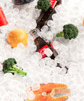 Ice-filled mix: Coca-Cola bottle, broccoli florets, orange half, and shrimp