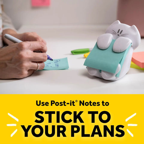 Person writing on paper next to cat themed pop up sticky note dispenser with 3x3 pink notes 45 sheets easy refill cute desk organizer