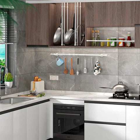 Modern kitchen with marble countertops, hanging utensils, cooking pots, and wall storage shelves for organization.