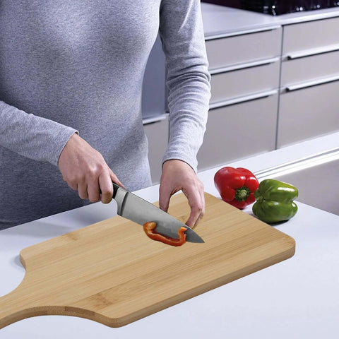 11x5 inch bamboo cutting board with handle on kitchen counter; person slicing red bell pepper.