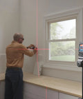 Man using GLL50-20 50 Ft Self Leveling Cross Line Laser With Integrated Magnetic Mount And Battery Flexibility For Quick No Hassle Setup On Any Jobsite Weather Tough IP55 Rated in kitchen.