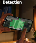 Person interacting with smartphone motion detection feature of the Outdoor Cam Pro Plug In Security Camera For Home Or Biz Surveillance Retinal 4K Video With Wide Angle And 10X Enhanced Zoom Low Light Night Vision White.