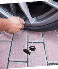 Person installing Spare Tire Hold Down Bolt For Secure Mounting, Fits Volkswagen Models, next to car wheel
