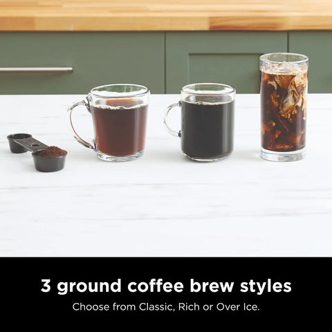 Three glass cups showing classic, rich, and iced coffee brewed styles with scoop of ground coffee in kitchen setting.
