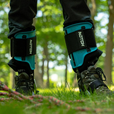 Steel Tree Climber Gaffs With Ergonomic Shank And 20 Plus Cuff Adjustment Points in use in a forest setting