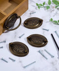 4 Pack Antique Oval Bail Drawer Pulls 3.3 Inch Bronze Wheat Pattern Farmhouse Vibe Vintage Cabinet Handles With Screws For Vanity Nightstand Wardrobe Cupboard Knobs Hardware displayed on a marble surface with screws and a screwdriver nearby