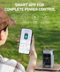 Person using a smartphone app to control C300 DC Portable Power Station 288Wh LiFePO4 Battery 300W Solar Generator in a grassy area.