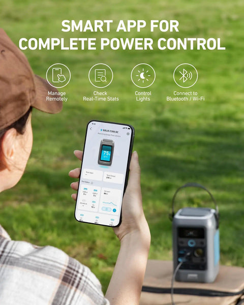 Person using a smartphone app to control C300 DC Portable Power Station 288Wh LiFePO4 Battery 300W Solar Generator in a grassy area.