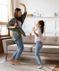 Mother and daughter dancing on a rug using 8 Pack Rug Gripper Pads For Hardwood Floors No Damage Non Slip For Area Rugs Reusable Carpet Tape.