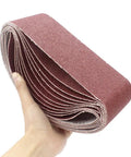 Person holding Rugged 3X21 Inch Sanding Belts, 12 Pack 80 Grit Aluminum Oxide Open Coat ideal for woodworking and belt sanders