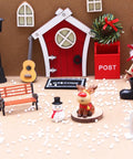 Christmas-themed miniature scene with tiny park street bench, guitar, snowman, reindeer, and red post box, dollhouse decor.