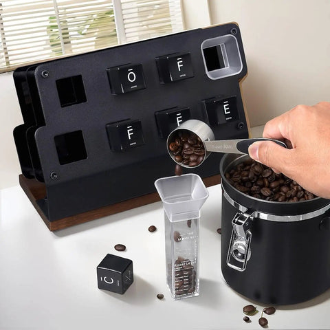 Coffee Bar Game Changer Clear Airtight Bean Storage Jars On Solid Walnut Base Heavy Duty Steel Frame Rack With Six Tubes And Two Funnels Real Deal Countertop Bean Keeper filled with coffee beans and measuring scoop.