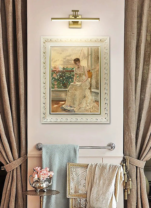 Brass Gold LED Picture Light with Adjustable Swing Arm illuminating framed painting in gallery setup, 15.5 Inch, 7W, 3000K