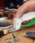 Hand using Portable Handheld Knife Sharpener With V Notch Edge Restorer on a knife blade near tools on wooden surface.