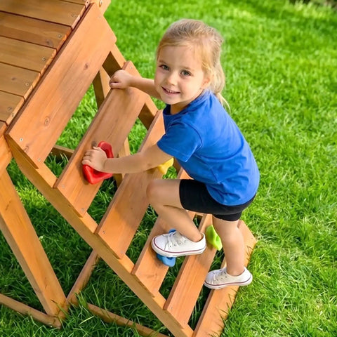 Child climbing wooden ladder on Wooden Backyard Playset With Monkey Bars And Wave Slide For Kids Ages 3 To 6 Includes 2 Belt Swings