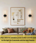 Battery Operated Wall Sconces Set of Two, Black and Gold Wall Light fixtures with Wireless Remote Control，Rechargeable Dimmable, stylishly placed in a modern living room.