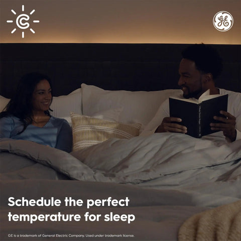 Couple in bed with blankets, man holding book, text overlay 'Schedule the perfect temperature for sleep', GE logo visible.