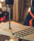Topshelf 39 Piece Countersink Drill Bit And Wood Plug Cutter Set With Deburring Tool Step Bits And High Speed Steel Hex Shank Multipurpose Drill Kit drilling into wood with a twist drill bit.