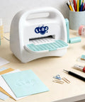 Portable Mini Die Cutting Machine With 3 Inch Opening, Foldable Manual Embossing Kit For Kids And Beginners on a crafting desk