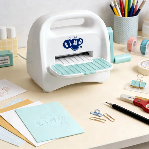 Portable Mini Die Cutting Machine With 3 Inch Opening, Foldable Manual Embossing Kit For Kids And Beginners on a crafting desk