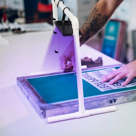 Person using the 50W LED UV Screen Printing Exposure Light Kit With PVC Lamp Stand, Two S Shaped Hooks, And Six Cable Ties