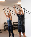 Solid Dual Sliding Wall Anchor Rail System With Adjustable Height For Resistance Bands And Suspension Trainers Made From Heavy Duty Aluminum in use by two people.
