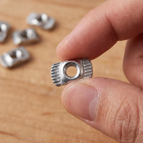 Close-up of a hand holding an M3 Hammer Head T slot fastener from Hella Sturdy 150 Piece Sliding T Nut Set for DIY builds.