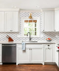 Calacatta Style Peel and Stick Backsplash Tiles 10 Sheets Self Adhesive Aluminum Composite Glass Mosaic for Kitchen Bathroom Fireplace and RV DIY Friendly Easy Install Heat Resistant Includes Gloves in modern white kitchen with wooden floor and window view.