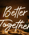 Close-up of a warm white neon sign reading 'Better Together', perfect for weddings or home decor.