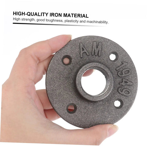 Hand holding a vintage iron floor flange from the Two Pack Vintage Malleable Iron Floor Flange Set for DIY projects.