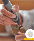Close-up of a gray Dremel Stylo+ engraving pen polishing a wooden leaf pendant.