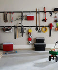 Must Have FastTrack Garage Hook Set 6 Pack Heavy Duty Powder Coated Metal Hangers For Ladders Tools Ropes Hoses Bikes And More Installs On Rails Easily Holds Up To 25 Lbs Each, various garage tools organized on hooks and shelves on wall.