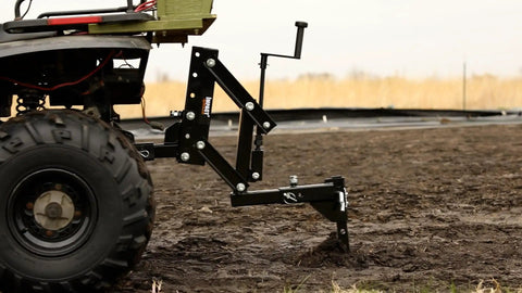 New Soil Kit For ATV UTV And Tractors Includes 1 Point Lift Cultivator Disc Plow And Middle Buster in action on a muddy field.