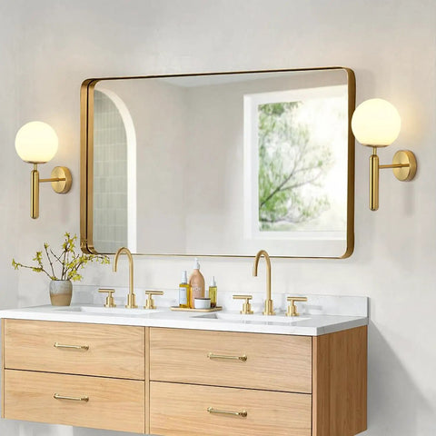 Milk Glass Globe Wall Sconce With Brushed Brass Body In Mid Century Modern Gold Finish beside bathroom mirror