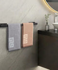 Stick On Stainless Steel Towel Bar 24 Inch Matte Black No Drill Wall Shelf Rack Hang On Towel Holder with towels in bathroom.