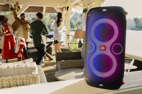 PartyBox 110 Portable Party Speaker With Built In Lights And Deep Bass 160W Power glowing in outdoor party setting