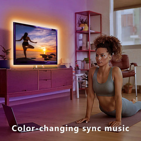 Woman doing yoga in a living room with a 12.5ft RGB LED Backlight Strip for 40 to 55 inch TVs, Bluetooth App Control atmosphere.