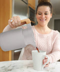 Woman pouring coffee from 50 Oz Thermal Coffee Carafe Stainless Steel Insulated Dispenser Keeps Your Brew Hot Or Cold For Hours