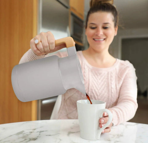 Woman pouring coffee from 50 Oz Thermal Coffee Carafe Stainless Steel Insulated Dispenser Keeps Your Brew Hot Or Cold For Hours