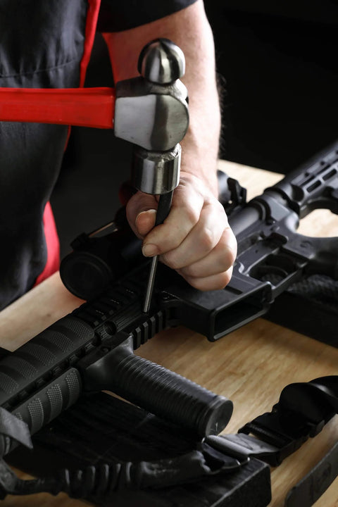 Person using Nine Piece Roll Pin Punch Set Pro Grade With Durable Heat Treated Drop Forged Steel Pins on a gun for repair