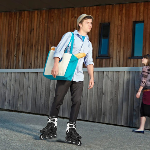 Man skating outdoors on black inline skates, holding a bag with baguette, wearing casual attire and rollerblades.