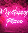 Pink LED Neon Light Sign My Happy Place Two Panel Wall Decor For Home Bar Bedroom Living Room Kid Room Wedding Gift 12V Power Adapter Included Bright Fun Glow That Feels Cozy And Cool, glowing against pink flowers.