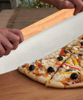Using the steel pizza cutter from the 4 Piece Rectangle Pizza Stone Set 15 Inch For Oven And Grill With Oak Pizza Peel to slice pizza.