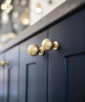 Soft Champagne Bronze Cabinet Knobs 12 Pack 1-3/16 Inch Round Zinc Alloy Hardware against dark cabinet