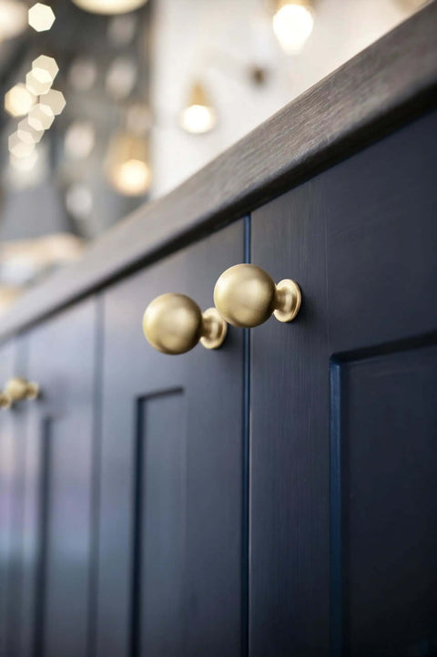 Soft Champagne Bronze Cabinet Knobs 12 Pack 1-3/16 Inch Round Zinc Alloy Hardware against dark cabinet