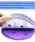 Close-up of 5 Inch 6Hole Alumina Sanding Discs, showcasing hook and loop backing, strong toughness, and purple color.